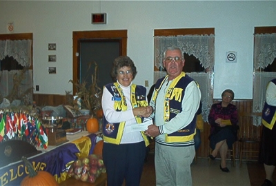 President Florence accepting cheque from Lion John Robertson Windsor & District Lions Club for joint project carried out