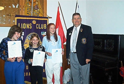 District Governor Earl Einarson presenting Peace Poster Awards to 1st place winner - Alicia Melanson, 2nd place winner - Kelsey Carey and 3rd place winner - Caitlin Cameron.